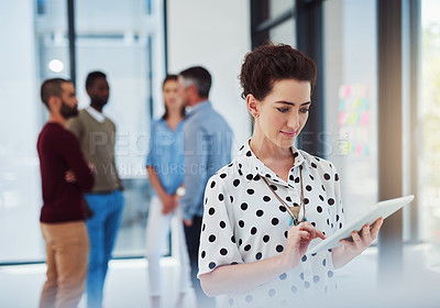 Buy stock photo Cropped shot of a businesswoman working in the office with her colleagues in the background