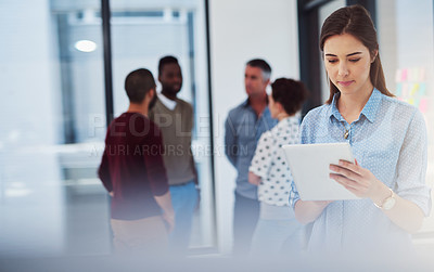 Buy stock photo Cropped shot of a young businesswoman working in the office with her colleagues in the background