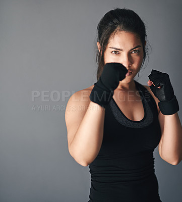 Buy stock photo Woman, portrait and fist in studio for fitness, cardio boxing and ready for fight tournament with power. Girl, serious and gray background for self defense with space, combat training and endurance.