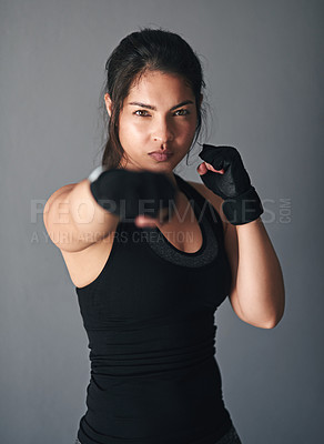 Buy stock photo Girl, portrait and fist in studio for fitness, cardio boxing and ready for fight tournament with power. Woman, serious and gray background for self defense with space, combat training and endurance.