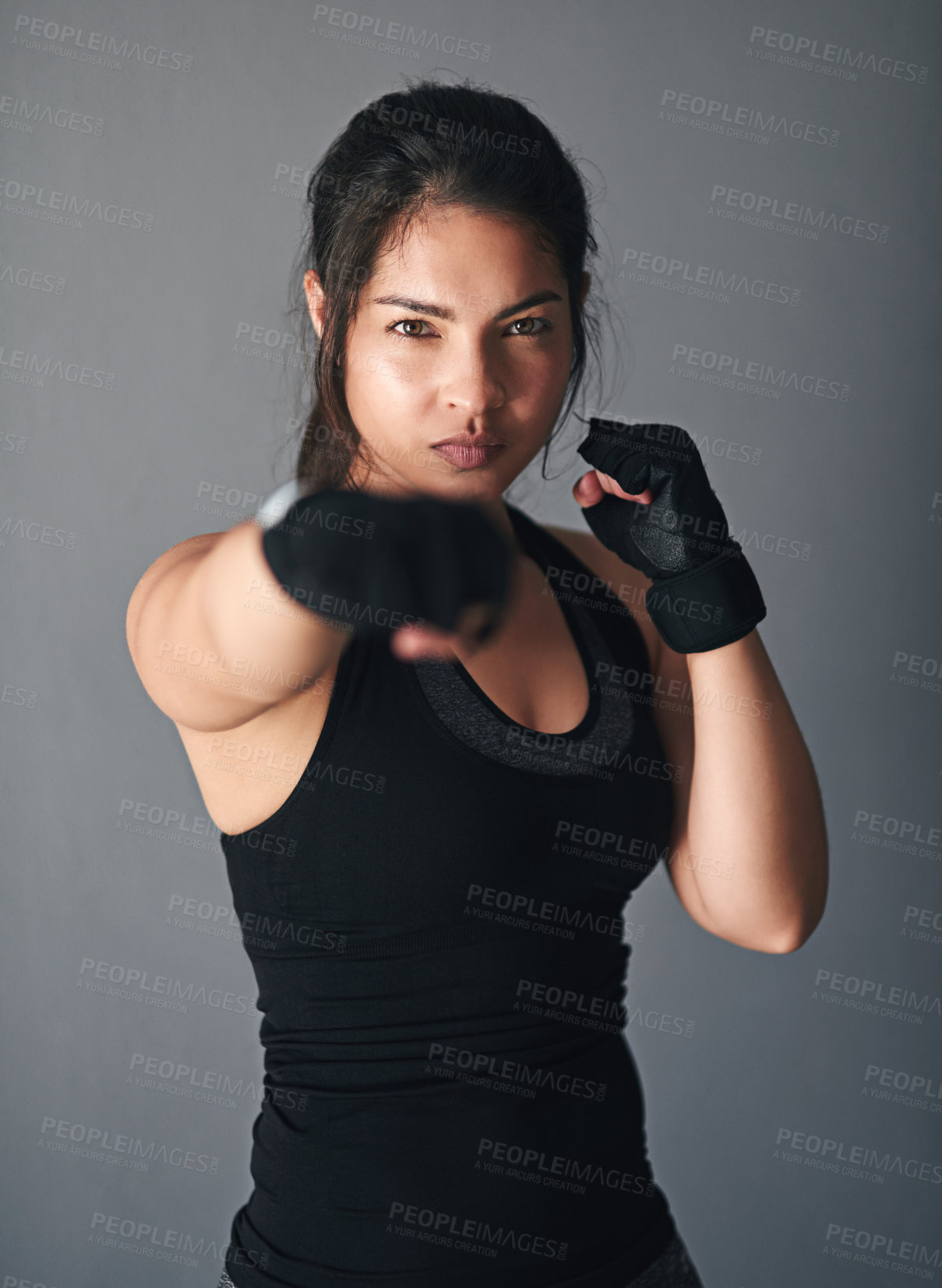 Buy stock photo Girl, portrait and fist in studio for fitness, cardio boxing and ready for fight tournament with power. Woman, serious and gray background for self defense with space, combat training and endurance.