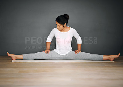 Buy stock photo Shot of an attractive young woman doing the splits in her yoga routine
