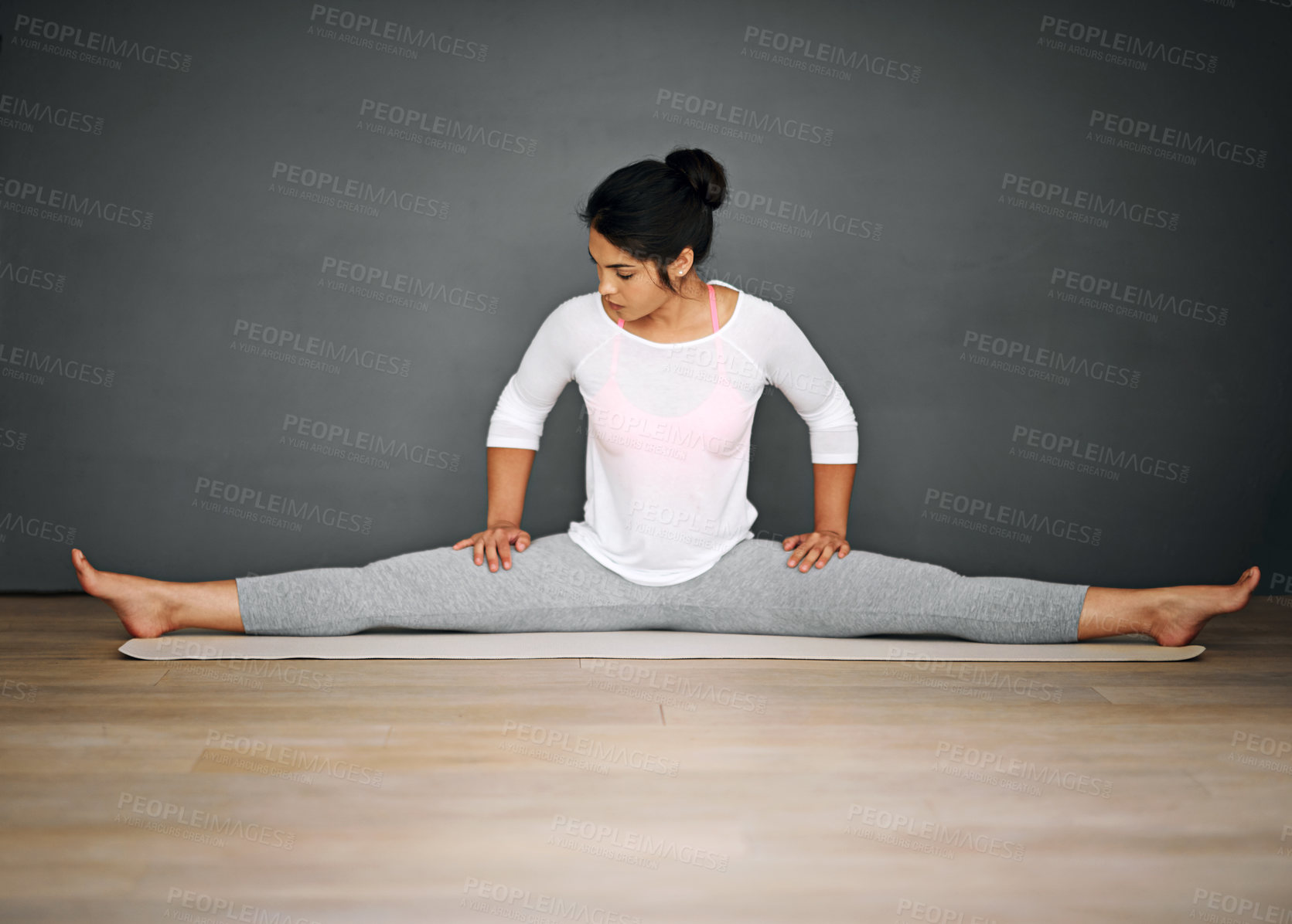 Buy stock photo Flexibility, woman and stretch in yoga splits on mat for health, wellness or leg training on gray wall background. Female yogi, pilates and floor for holistic wellbeing, mockup and fitness practice