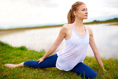 Buy stock photo Shot of a young woman doing yoga outdoors