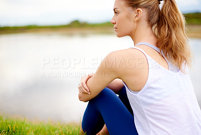 Buy stock photo Rearview shot of a young woman sitting outdoors