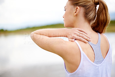 Buy stock photo Rearview shot of a young woman touching her shoulder