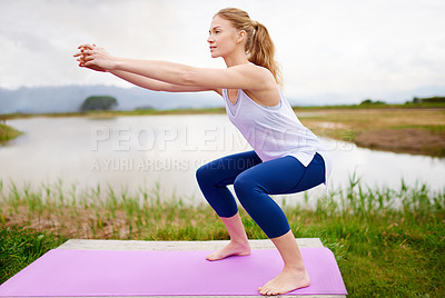 Buy stock photo Shot of a young woman doing squats on her yoga mat