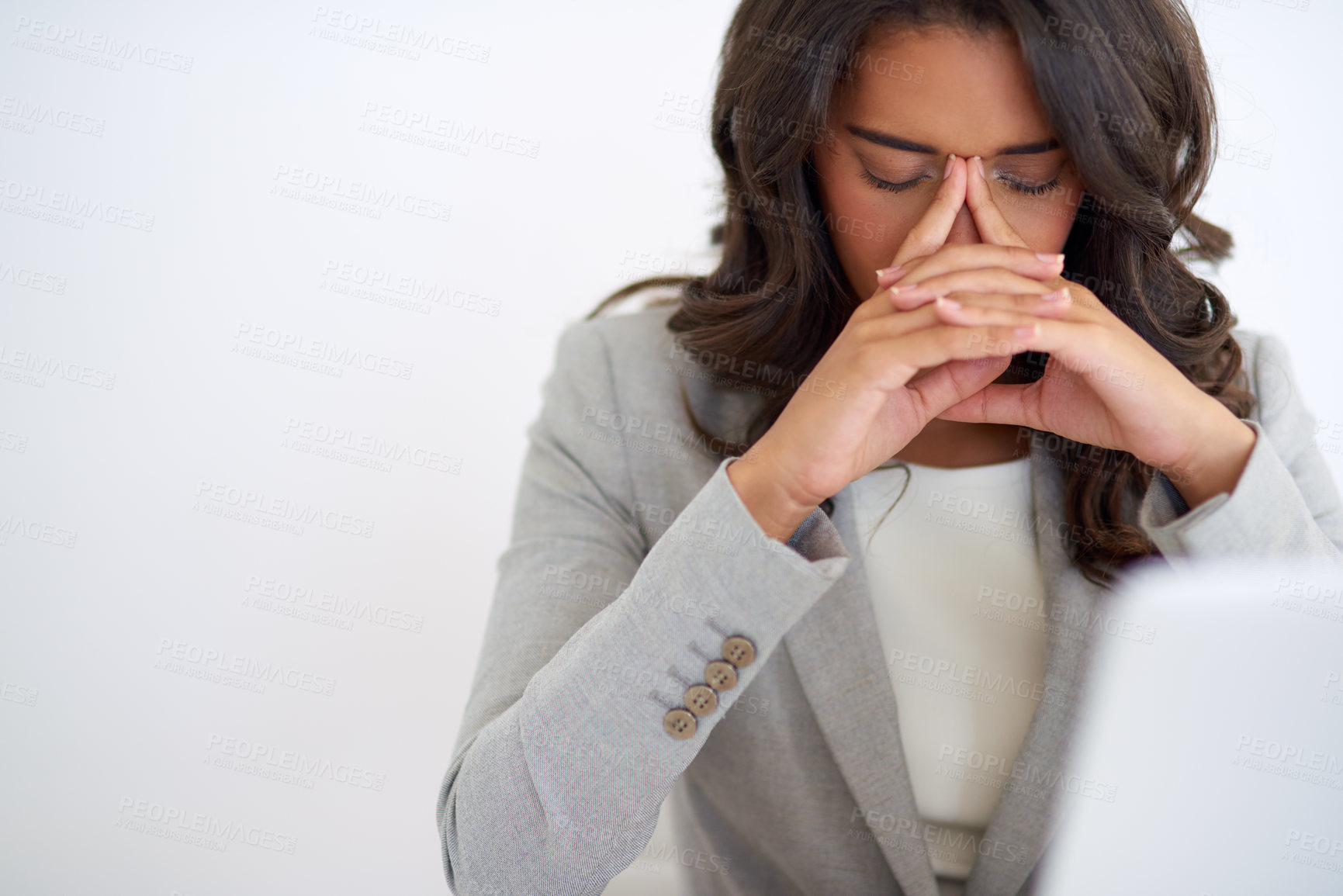 Buy stock photo Cropped shot of a young businesswoman looking stressed while working on her laptop