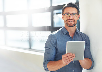 Buy stock photo Cropped portrait of a businessman working on his tablet in the office