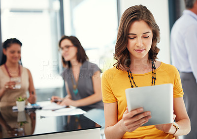 Buy stock photo Cropped shot of a young businesswoman using her digital tablet during a meeting