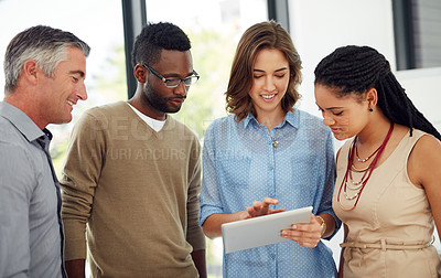 Buy stock photo Shot of a group of businesspeople discussing something on a digital tablet
