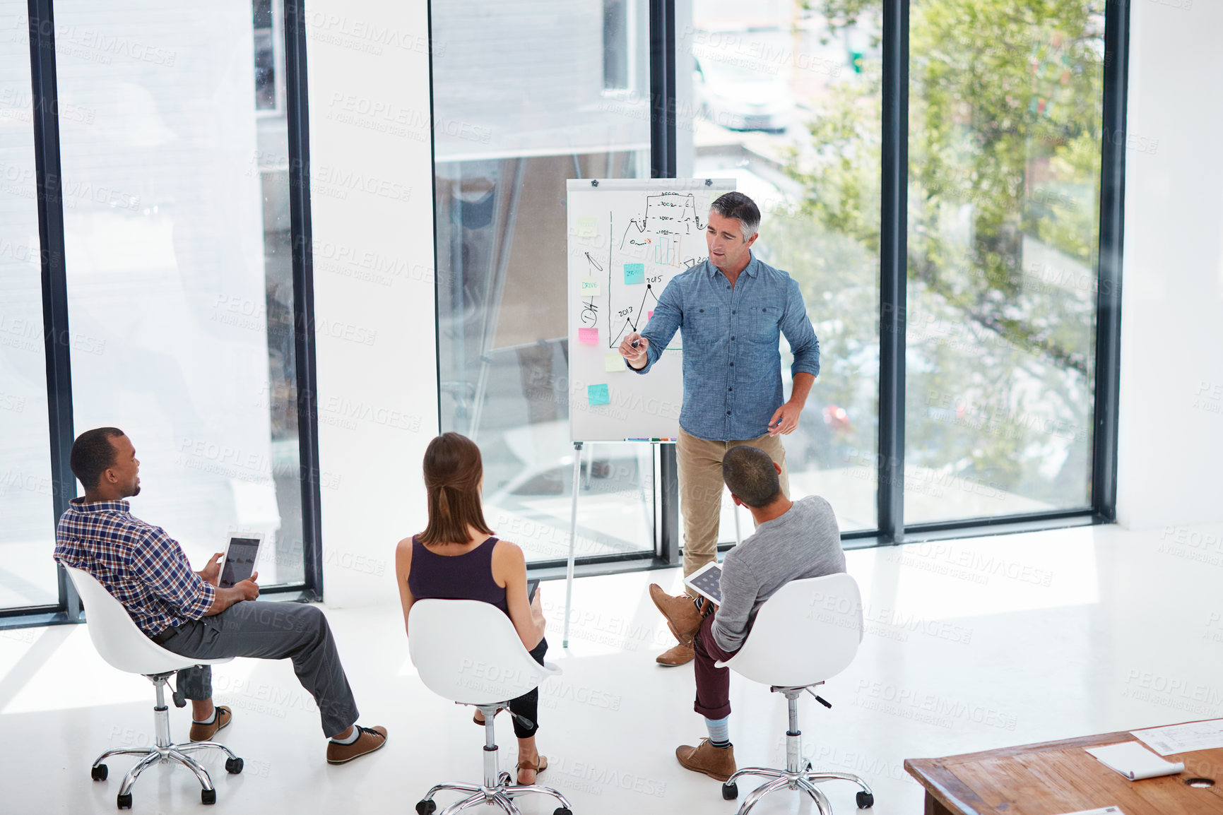 Buy stock photo Shot of a mature businessman giving a presentation in the boardroom