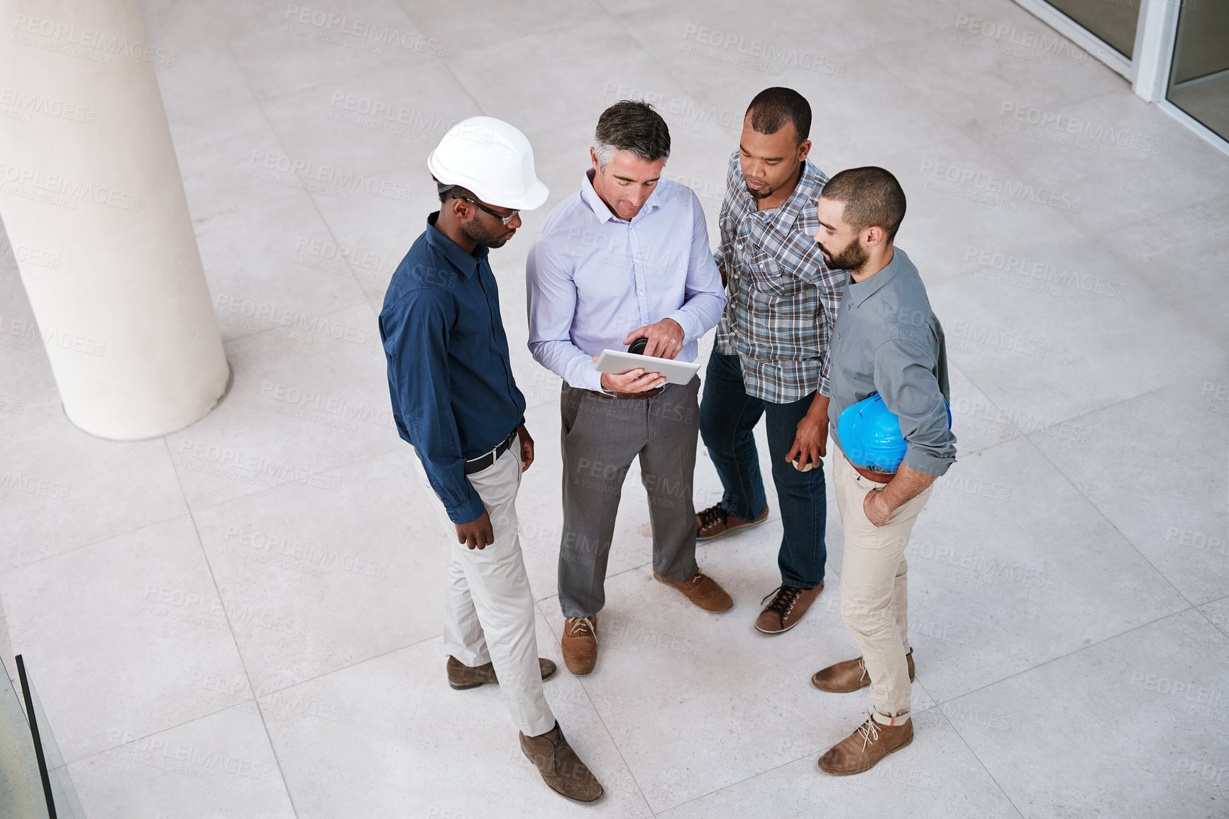 Buy stock photo High angle shot of businessmen talking in the lobby of their office