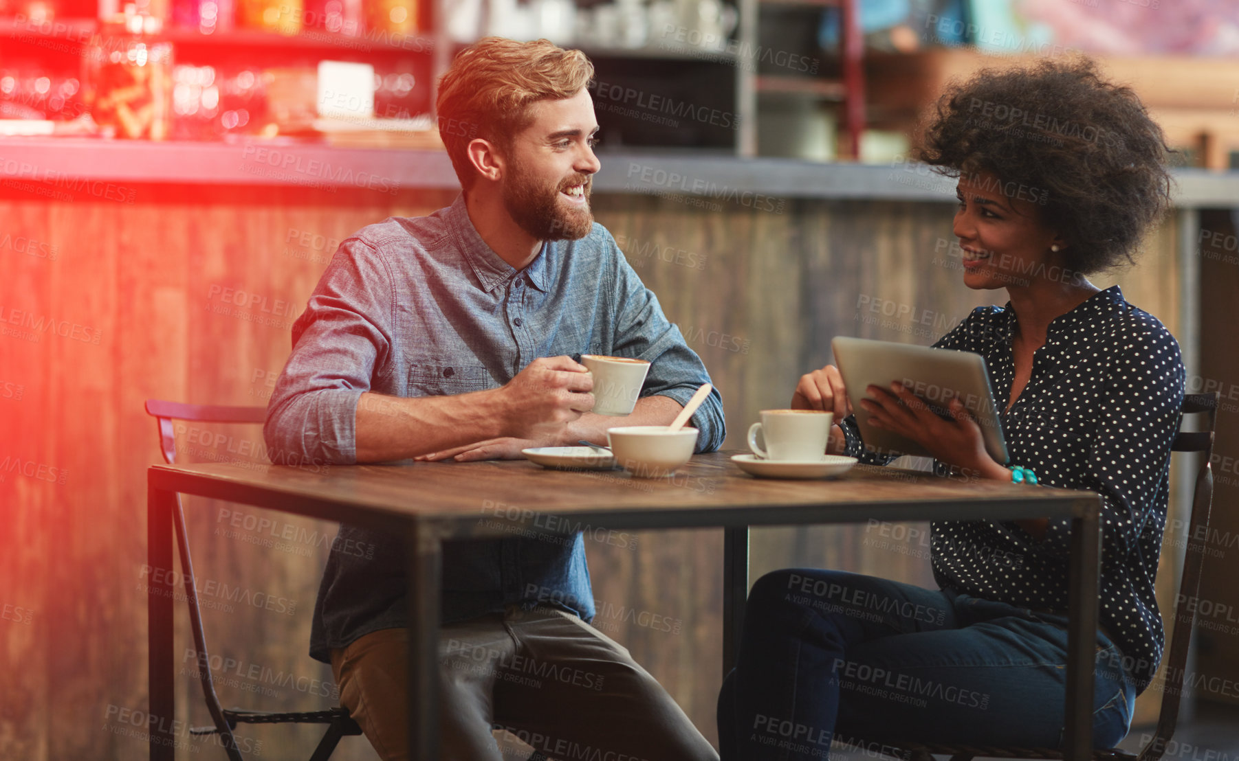 Buy stock photo Bonding, man and woman in cafe with tablet, social media post, relax and networking connection at table. Date, weekend conversation and happy couple in coffee shop with digital app, drink and smile