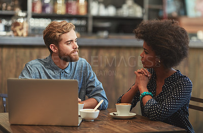 Buy stock photo Shot of a young couple using a laptop together on a coffee date