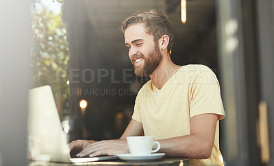 Buy stock photo Shot of a young man using a laptop in a cafe