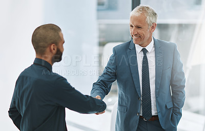Buy stock photo Cropped shot of two businessmen shaking hands in the office