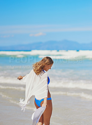 Buy stock photo Shot of a beautiful young woman walking on the beach