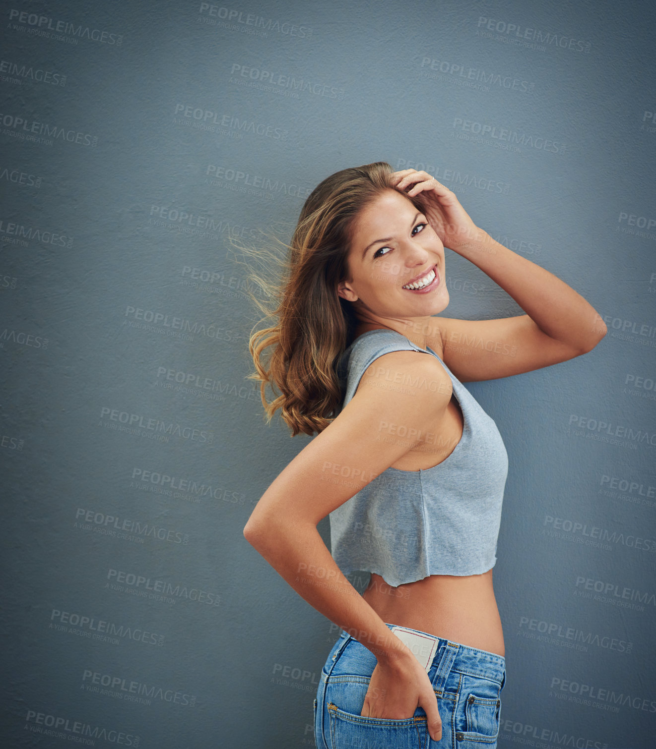 Buy stock photo Studio shot of a happy young woman posing against a gray background
