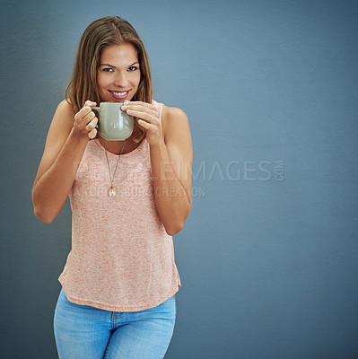 Buy stock photo Studio portrait of a young woman drinking a beverage against a gray background