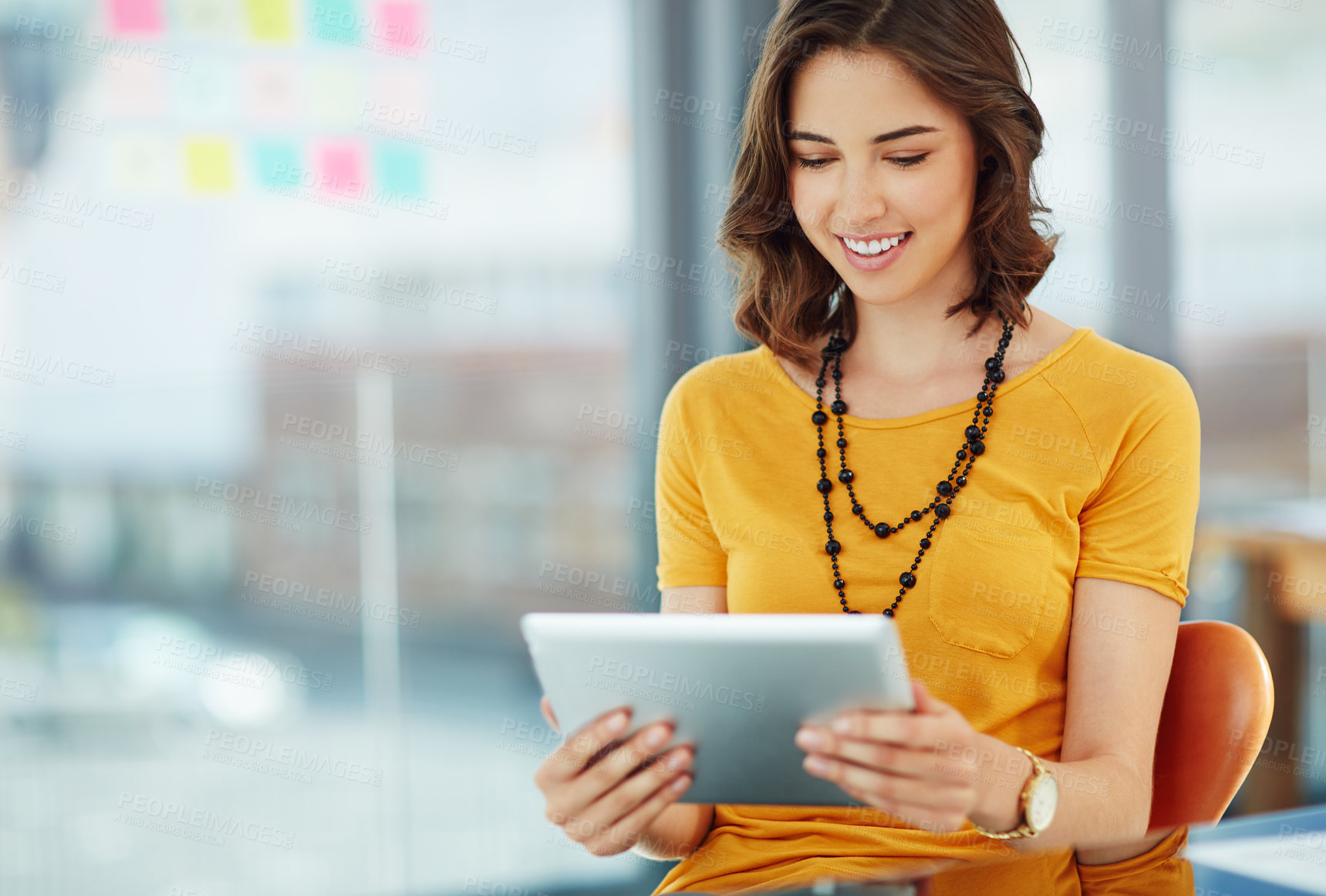 Buy stock photo Cropped shot of a young businesswoman working on her tablet in the office