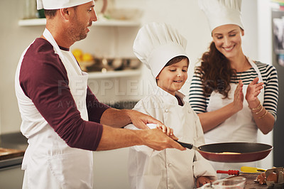 Buy stock photo Shot of a smiling family making pancakes together in the kitchen
