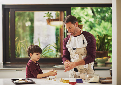Buy stock photo Shot of a father and his young son baking cookies together in the kitchen