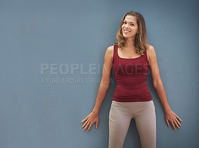 Buy stock photo Portrait of a smiling young woman posing against a gray background