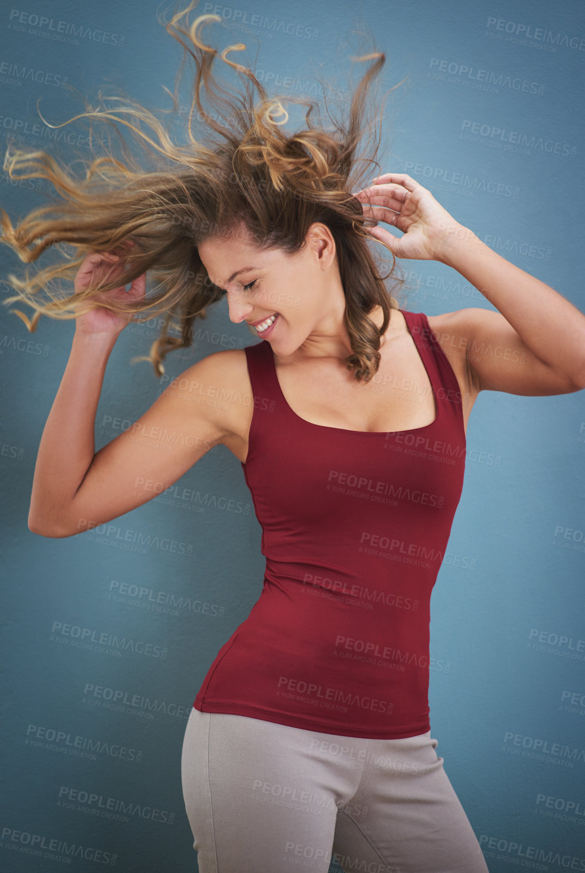 Buy stock photo Woman, dancing and crazy hair with wind, freedom and smile from wellness and healthy in studio. Excited, carefree and confidence with hairstyle flip and blue background ready for casual dancer class