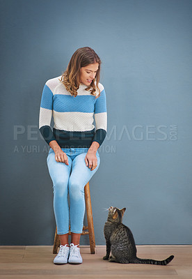 Buy stock photo Shot of a young woman looking at a cat