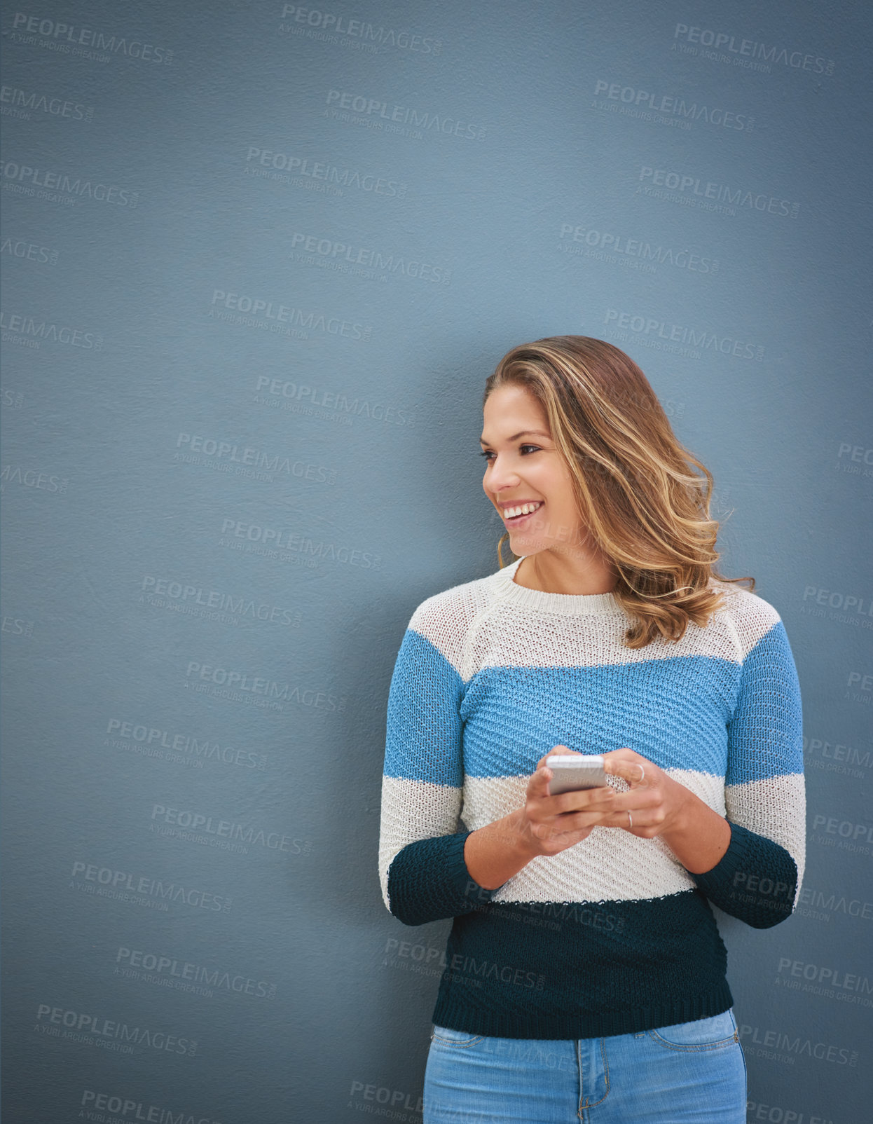 Buy stock photo Studio shot of a young woman using a mobile phone against a gray background