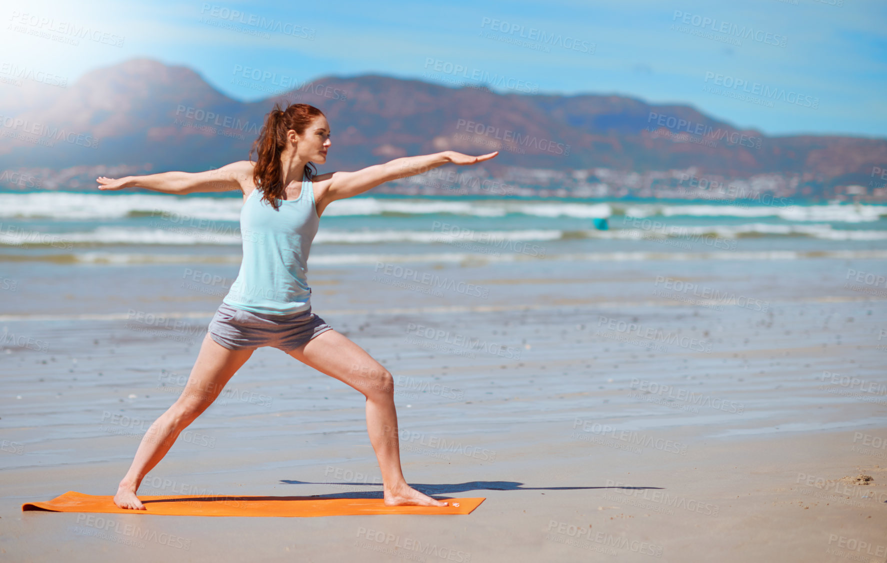 Buy stock photo Shot of a young woman practicing her yoga routine at the beach