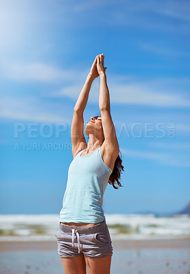 Buy stock photo Shot of a young woman practicing her yoga routine at the beach