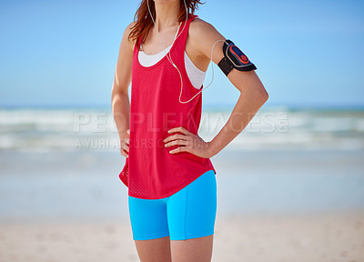 Buy stock photo Runner woman, beach fitness and music with earphones for podcast, workout and training motivation at ocean. Athlete girl, exercise or running for wellness by sea with focus, hands on hips or health