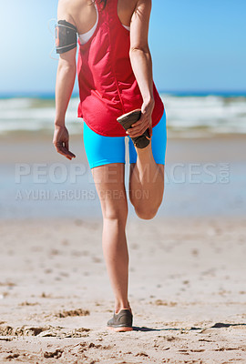 Buy stock photo Rearview shot of a young woman stretching before her run on the beach