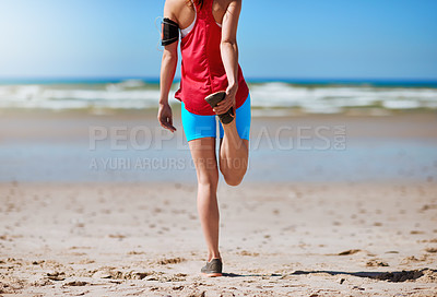 Buy stock photo Rearview shot of a young woman stretching before her run on the beach