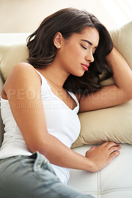 Buy stock photo Shot of a young woman asleep on her sofa