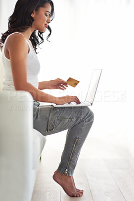 Buy stock photo Shot of a young woman using her credit card to make a purchase online