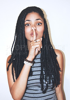 Buy stock photo Studio portrait of an attractive young woman with her finger on her lips