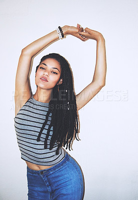 Buy stock photo Studio portrait of an attractive young woman with her hands above her head