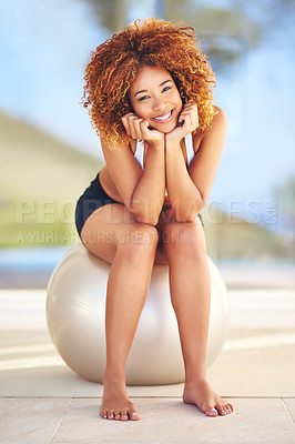 Buy stock photo Shot of a sporty young woman sitting on a swiss ball