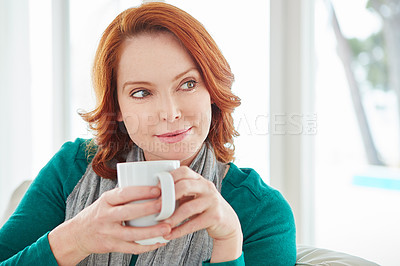 Buy stock photo Cropped shot of a mature woman drinking coffee while relaxing on the sofa at home