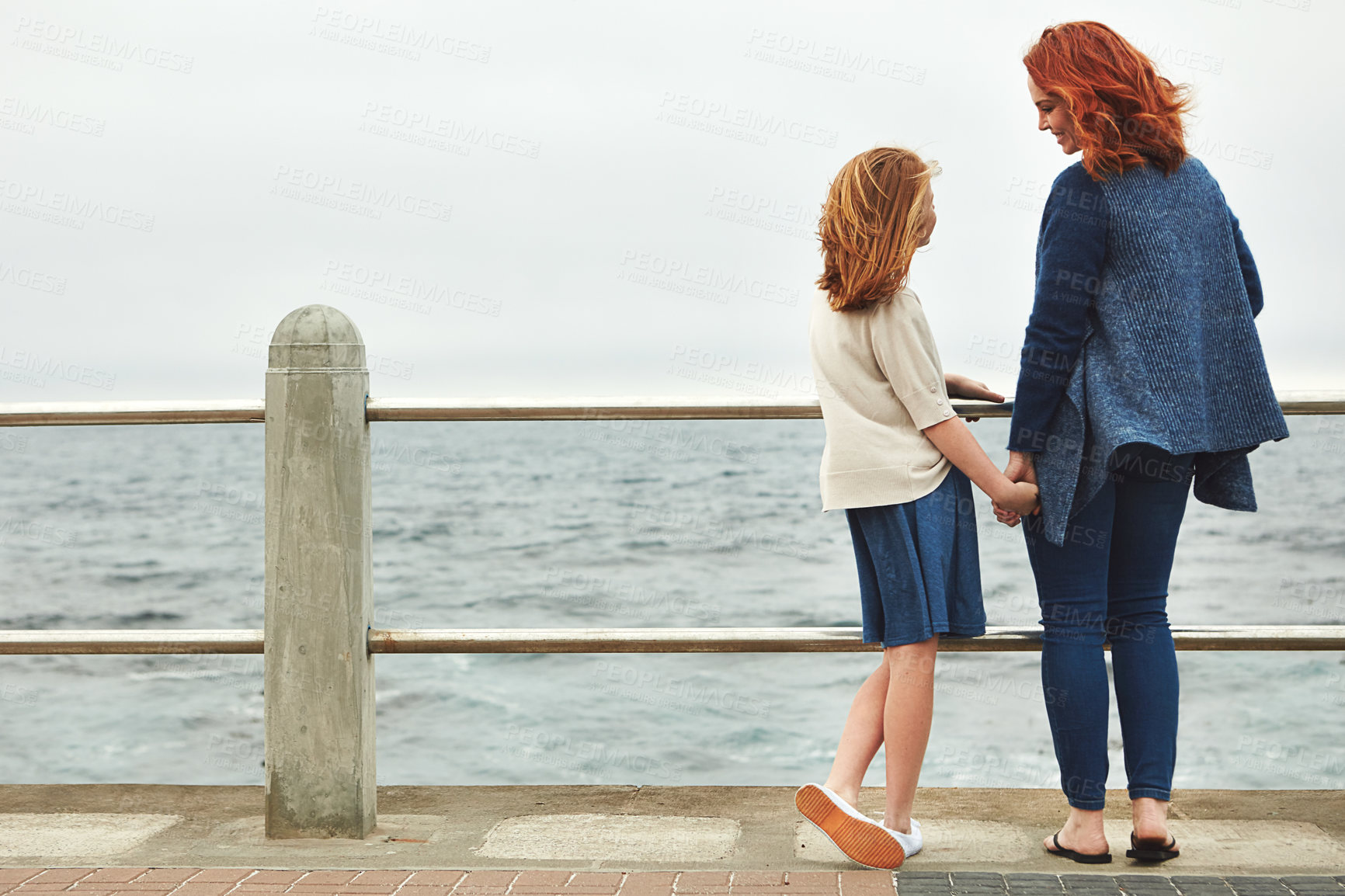 Buy stock photo Rearview shot of a woman and her young daughter at the waterfront