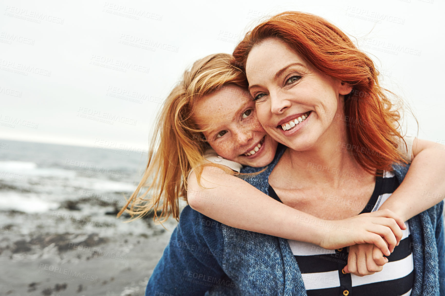 Buy stock photo Shot of a mature woman and her young daughter at the waterfront