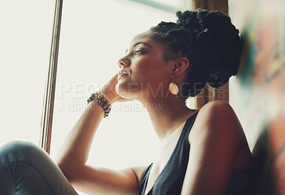 Buy stock photo Shot of an attractive young woman sitting by the window