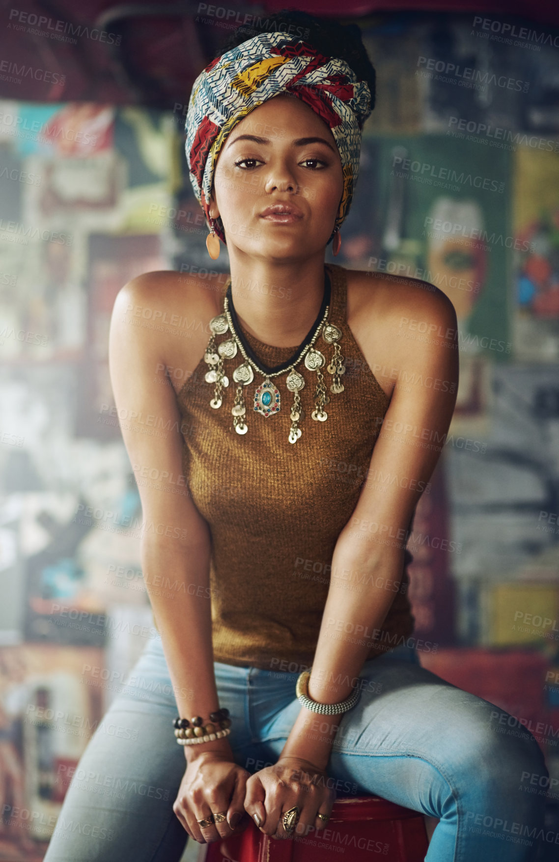 Buy stock photo Portrait, fashion and heritage with a black woman on a stool indoors with an African style turban. Model, culture and tradition with an attractive young female feeling empowerment or proud