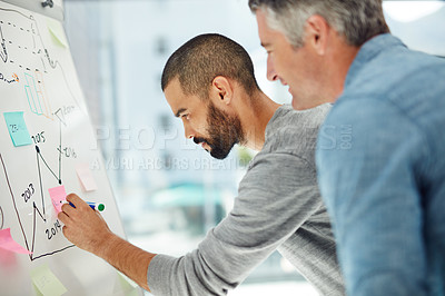 Buy stock photo Cropped shot of two businessmen working at a whiteboard