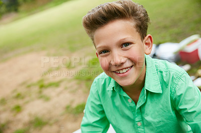 Buy stock photo Portrait of one happy young boy enjoying a picnic or summer camping trip in a garden outdoors with copy space. Face of smiling cheerful kid having fun at a park and feeling excited to explore nature