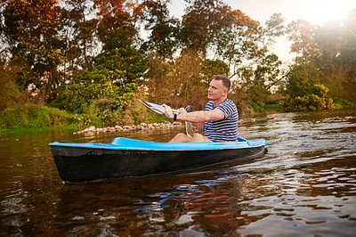 Buy stock photo Shot of a mature man rowing a boat on a lake
