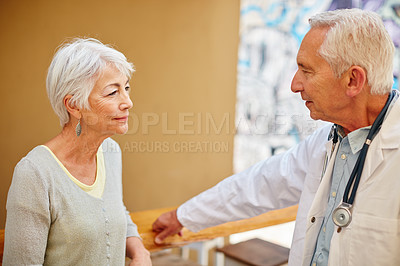 Buy stock photo Shot of a senior woman visiting her doctor